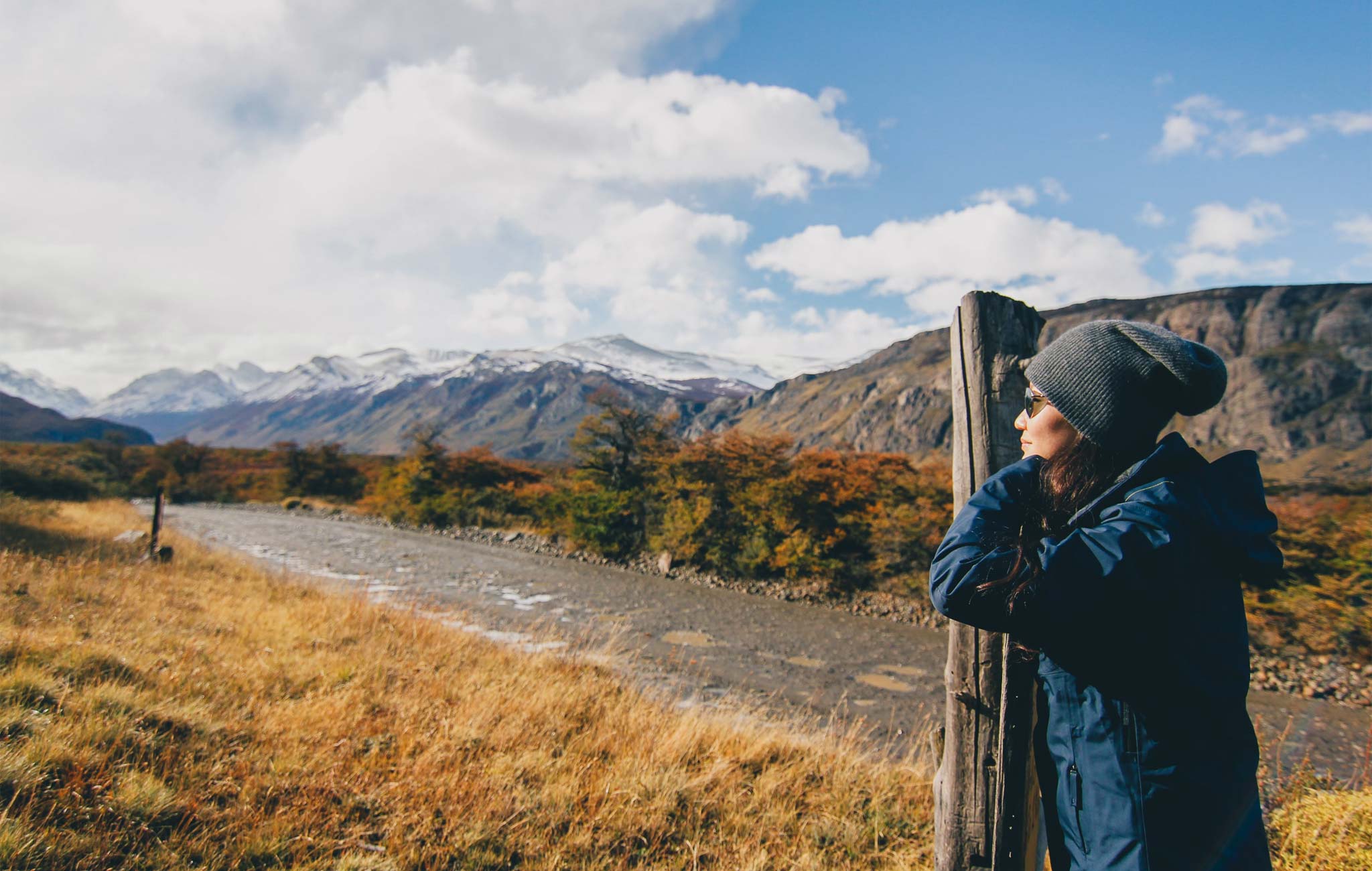 woman standing next to post in patagonia