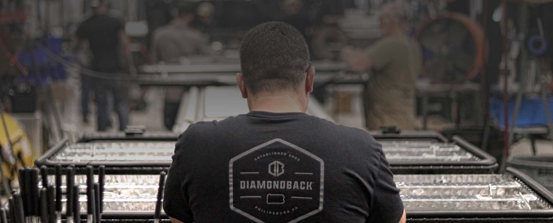 A Philipsburg man fits lock rods to a DiamondBack HD truck bed cover