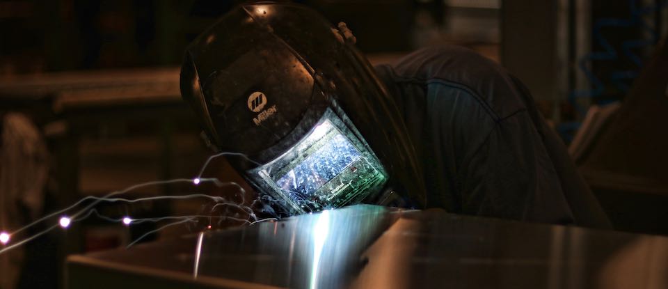 A DiamondBack employee welds a Cross Bin 13