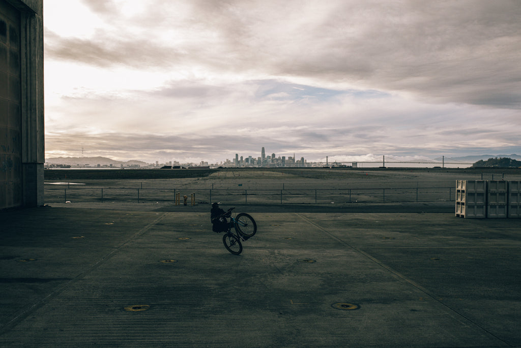 ride on bike on concrete, with the skyline of SF in the background, overcast