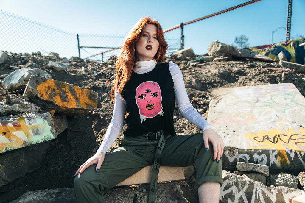 Model wearing black tank top with illustration of girl in a pink ski mask.