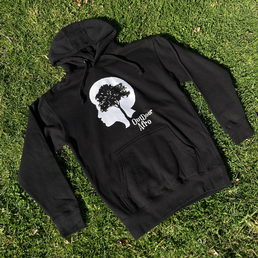 Image of black Outdoor Afro pullover hoodie photographed on grass.