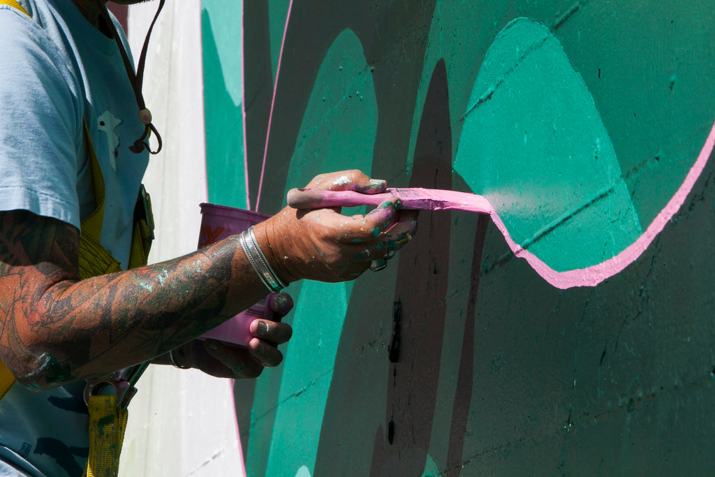 closeup of Jet Martinez while painting, tattooed arm, paintbrush