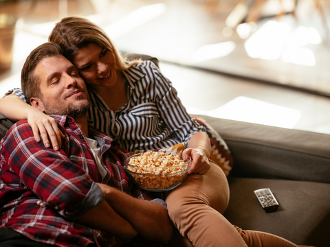 Couple watching tv with popcorn