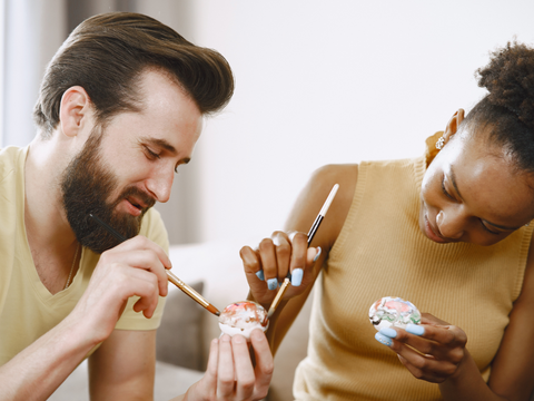 A couple painting eggs together