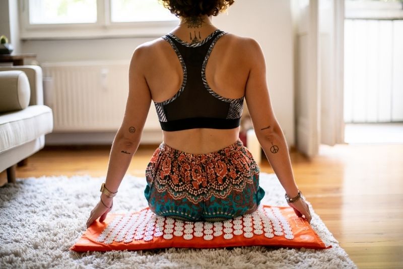 Female Person Sitting On ShaktiMat Acupressure Mat - Orange