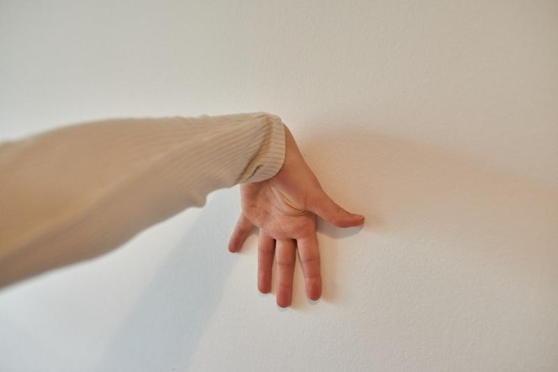 Hand stretching on the wall