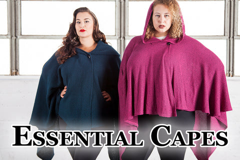 Essential Capes - Kat and Anastasia (two medium-light skinned models) wear knit capes, one dark green and the other pink. These two pieces are part of our many Essential Capes.