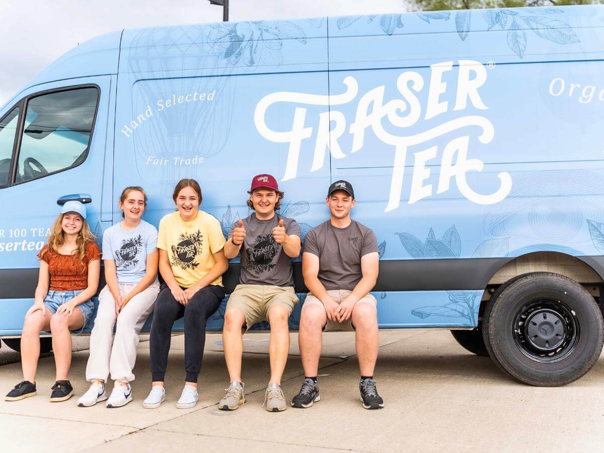 Fraser Tea family members by a blue Fraser Tea truck.