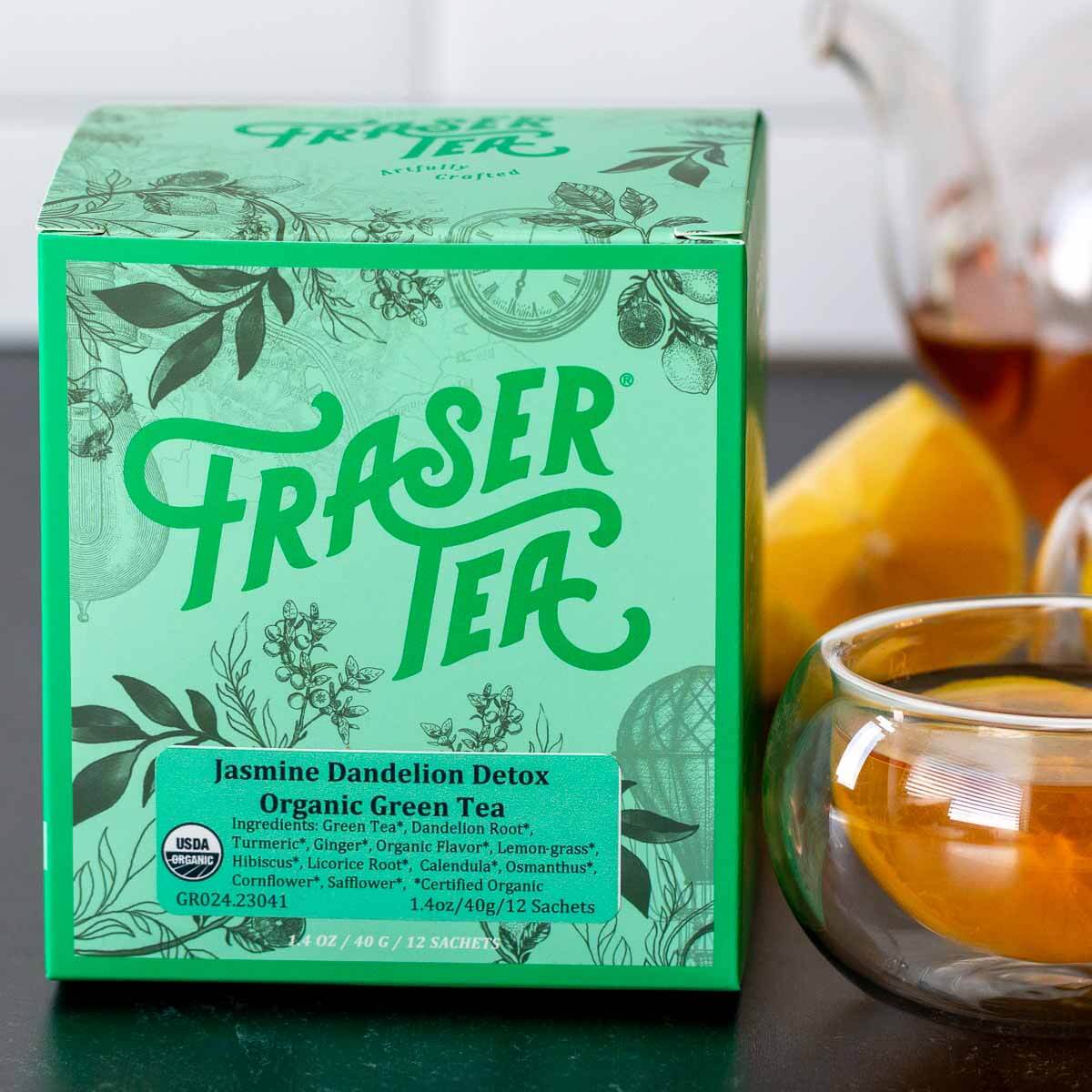 Box of Fraser Tea Jasmine Dandelion Detox Organic Green Tea with lemons and hot tea.