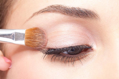Woman applying eye makeup.