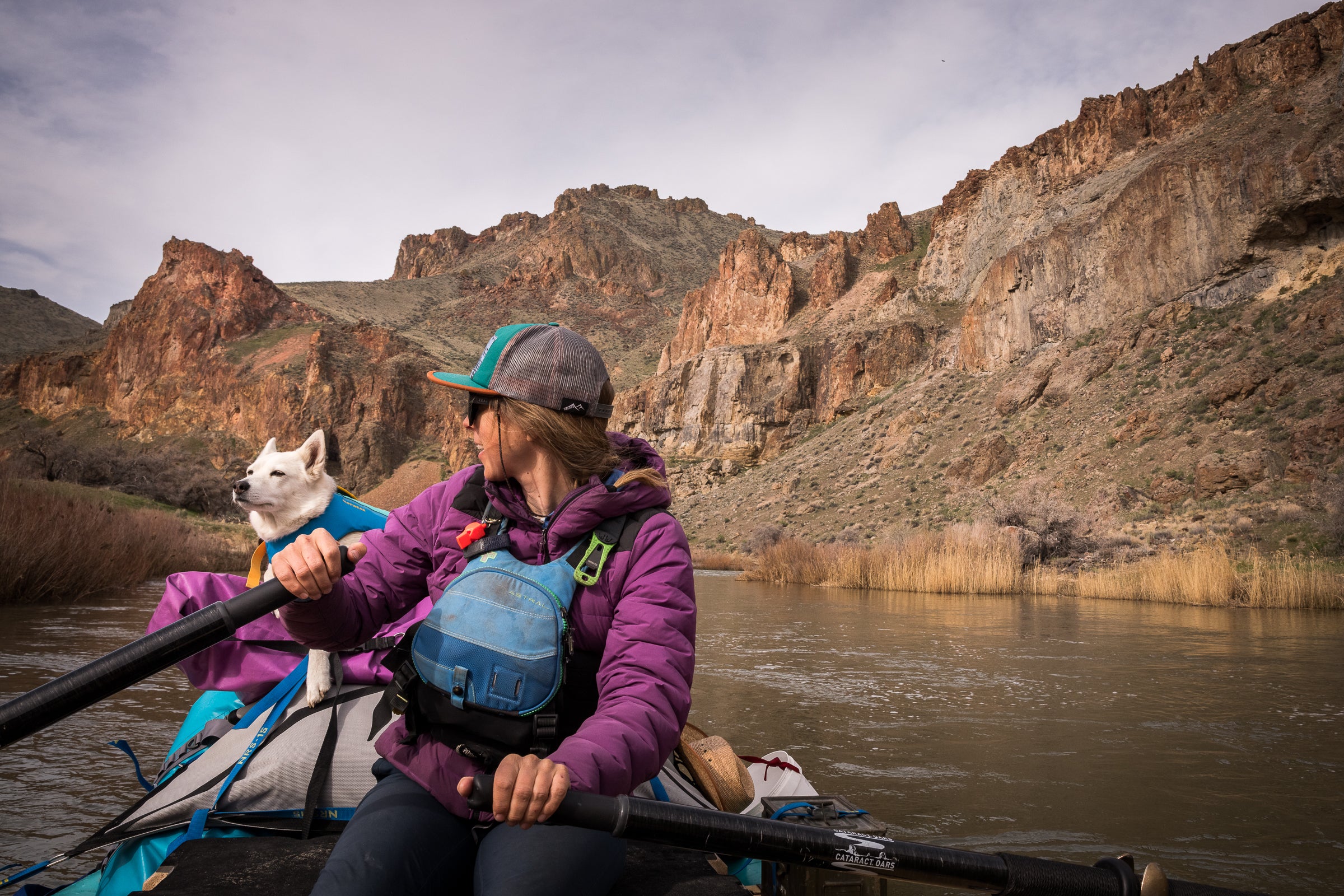 A woman and her dog go river rafting together. 