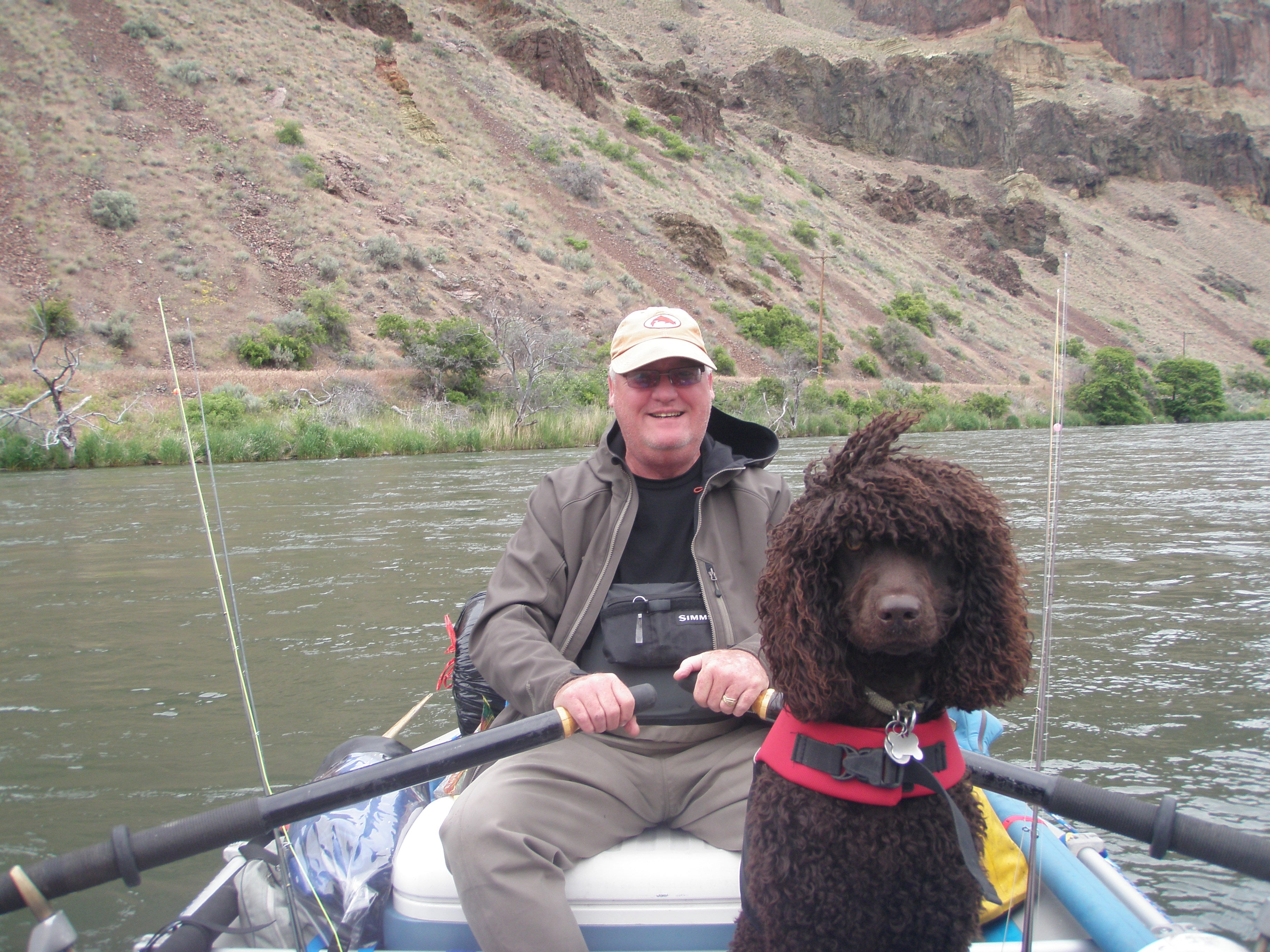 Clell and dog Midge on a boat in the river