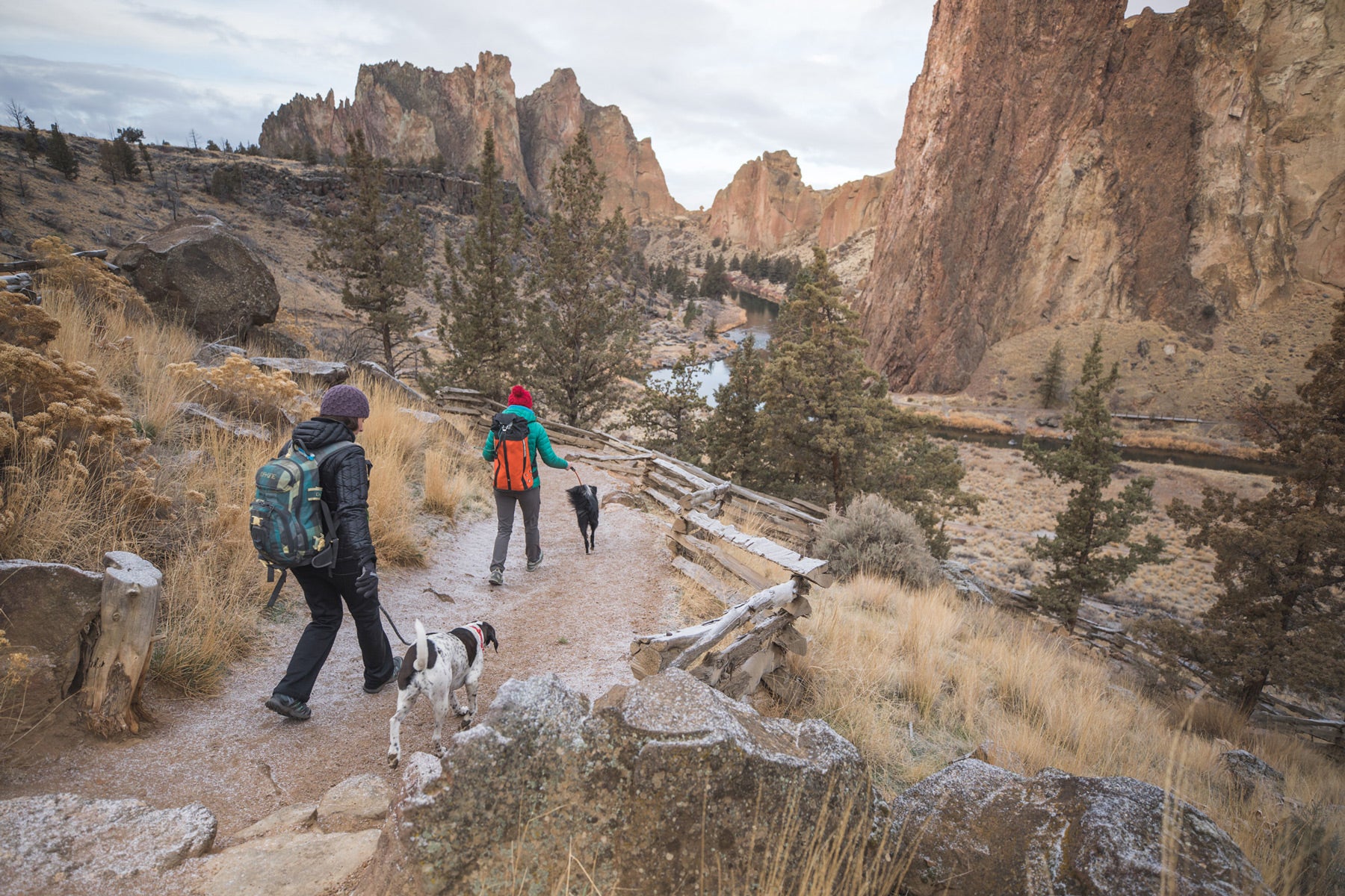Two climbers with dogs on knot-a-leashes descend on the trail at Smith.
