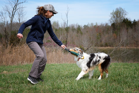 Maria with pacific ring toy playing tug with her dog.