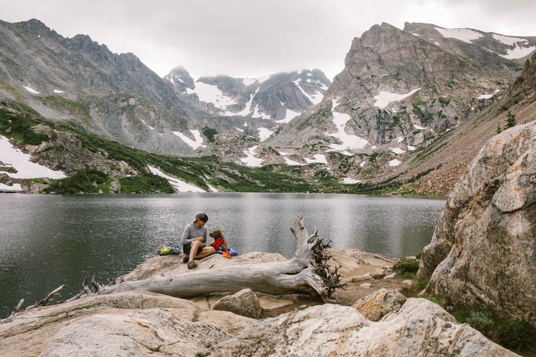 Nathan and Turkey sit on a rock by an alpine lake for a snack break.