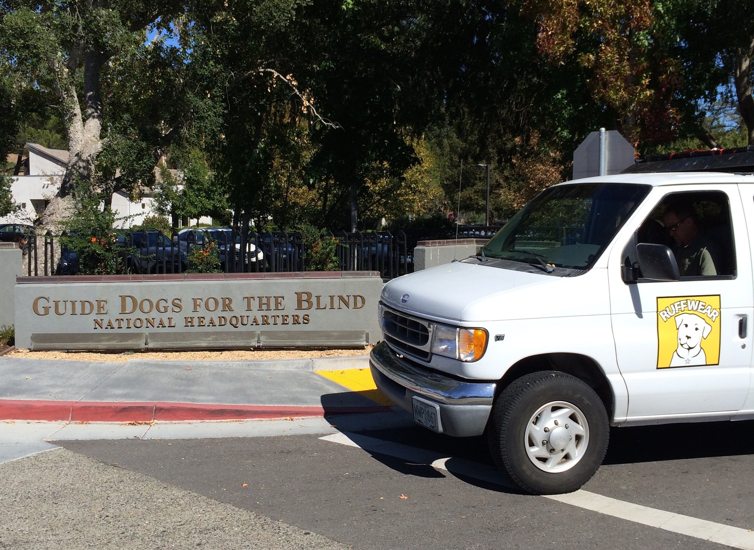 The Ruffwear van is parked in front of the Guide Dogs for the Blind campus sign. 