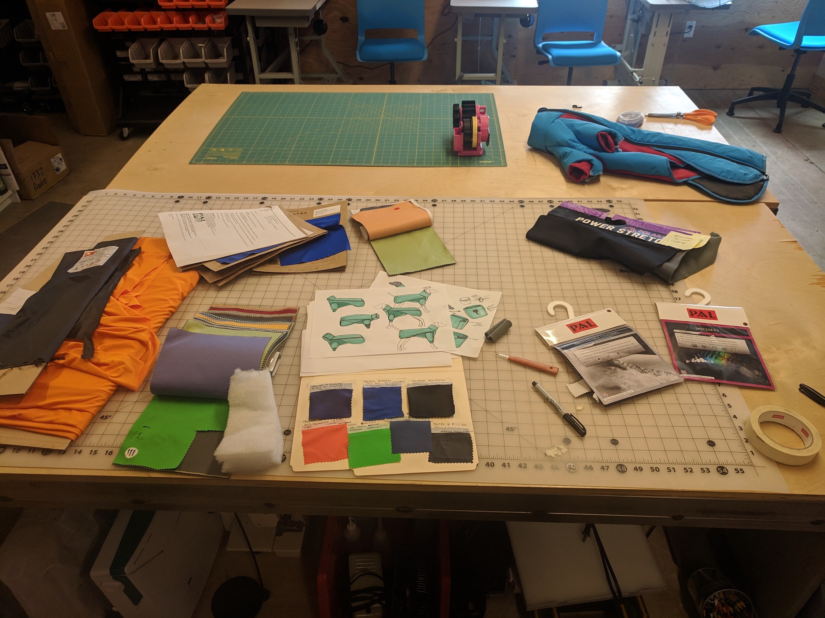 Designer's workbench with materials, prototypes, and sewing tools