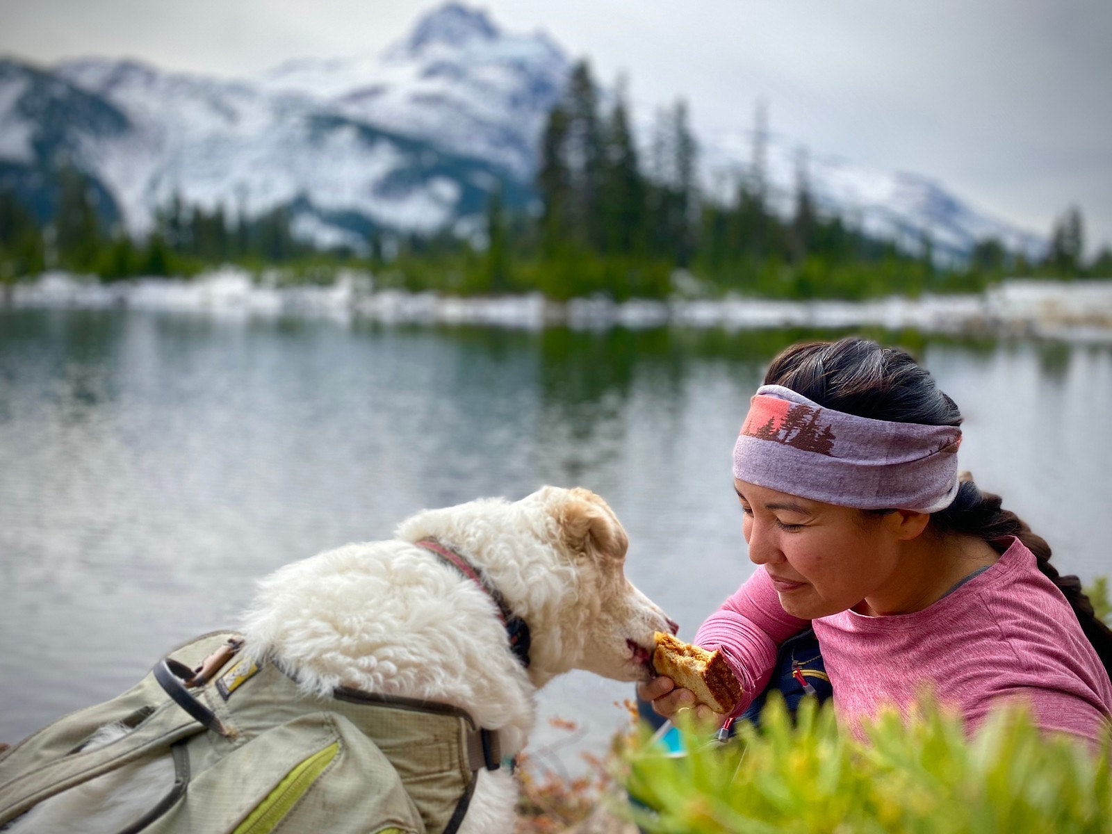 Theresa feeding cassie - who is wearing a singletrak pack - snacks on a trail run.