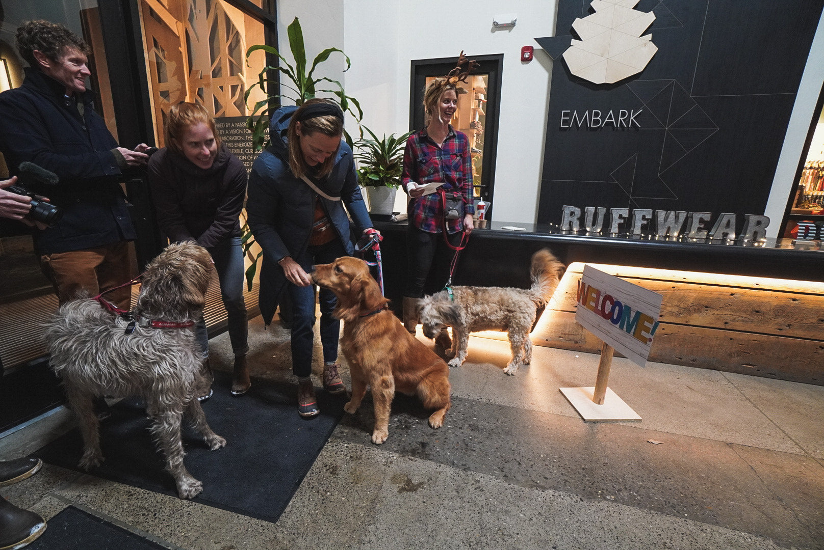 Three dogs enjoy puppuccinos while entering the Ruffwear Howliday Party.