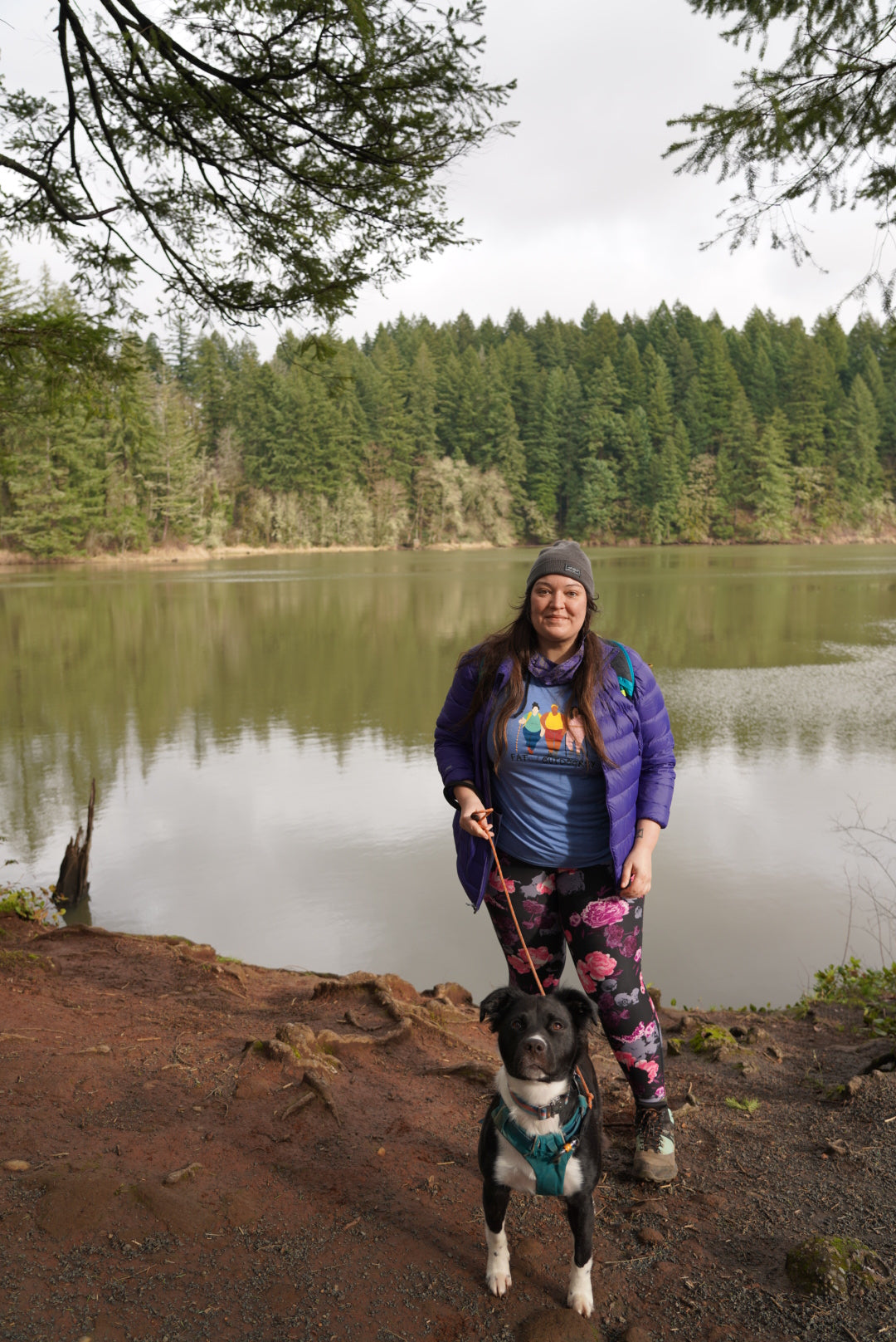 Jenny Bruso with dog in Flagline harness by the water on a hike.