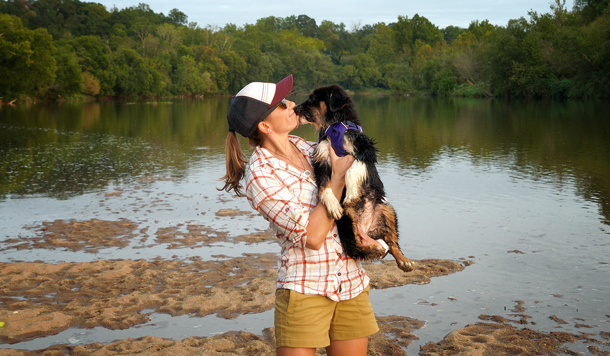 Maria holding her puppy in her arms getting kisses.