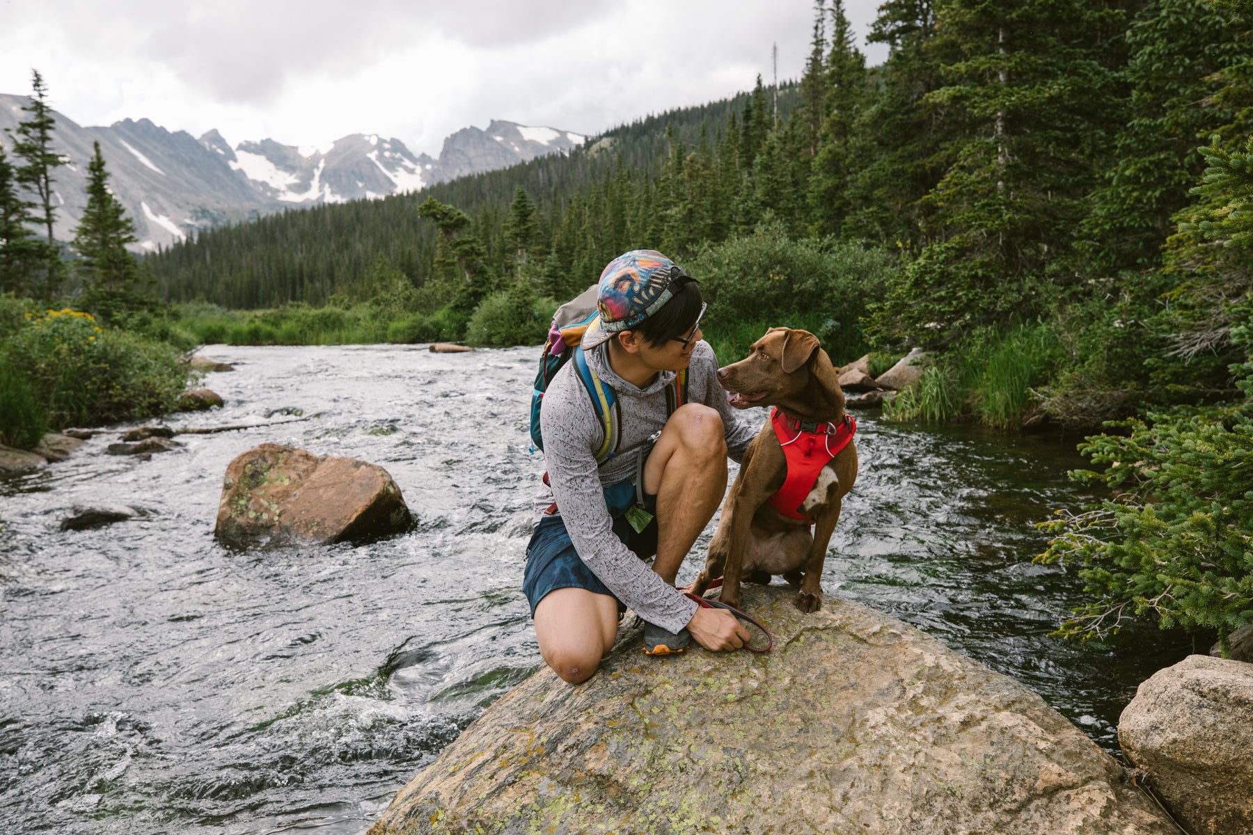 Nathan and Turkey look into each other's eyes while sitting on a rock in the river.