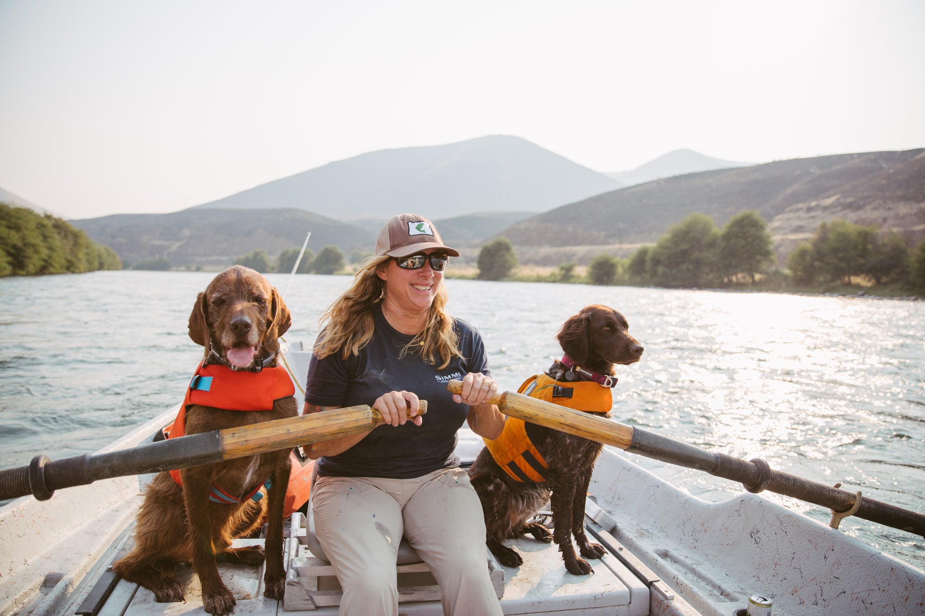 Mia with dogs Eddy and Cedar in Float coat dog life jackets in fishing boat on deschutes river.