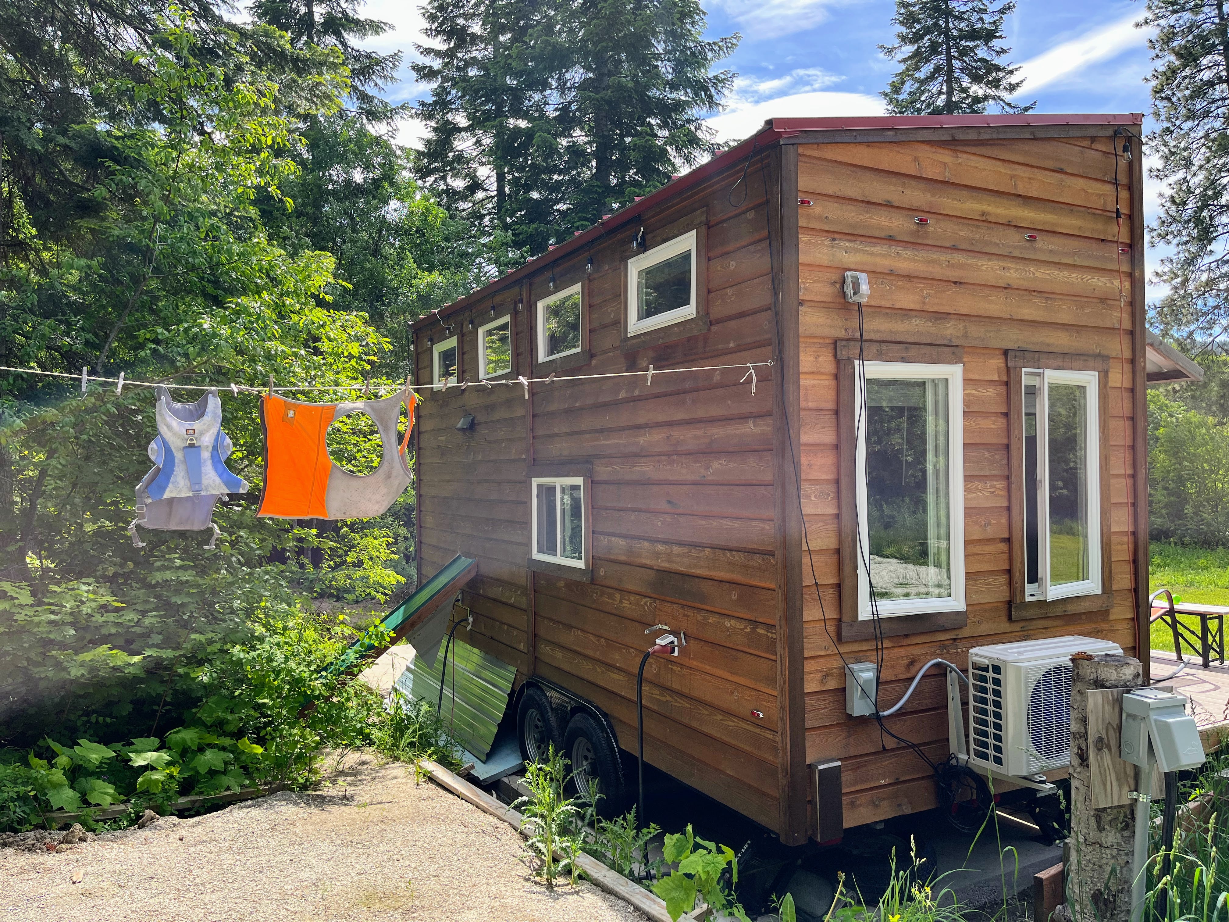 Two pieces of Ruffwear gear hang on a clothesline outside a tiny home. 