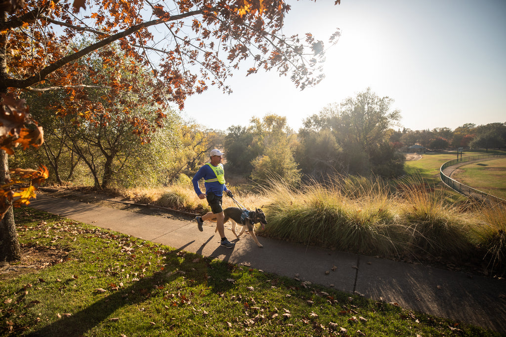 Richard & Klinger run along a paved trail in a park.