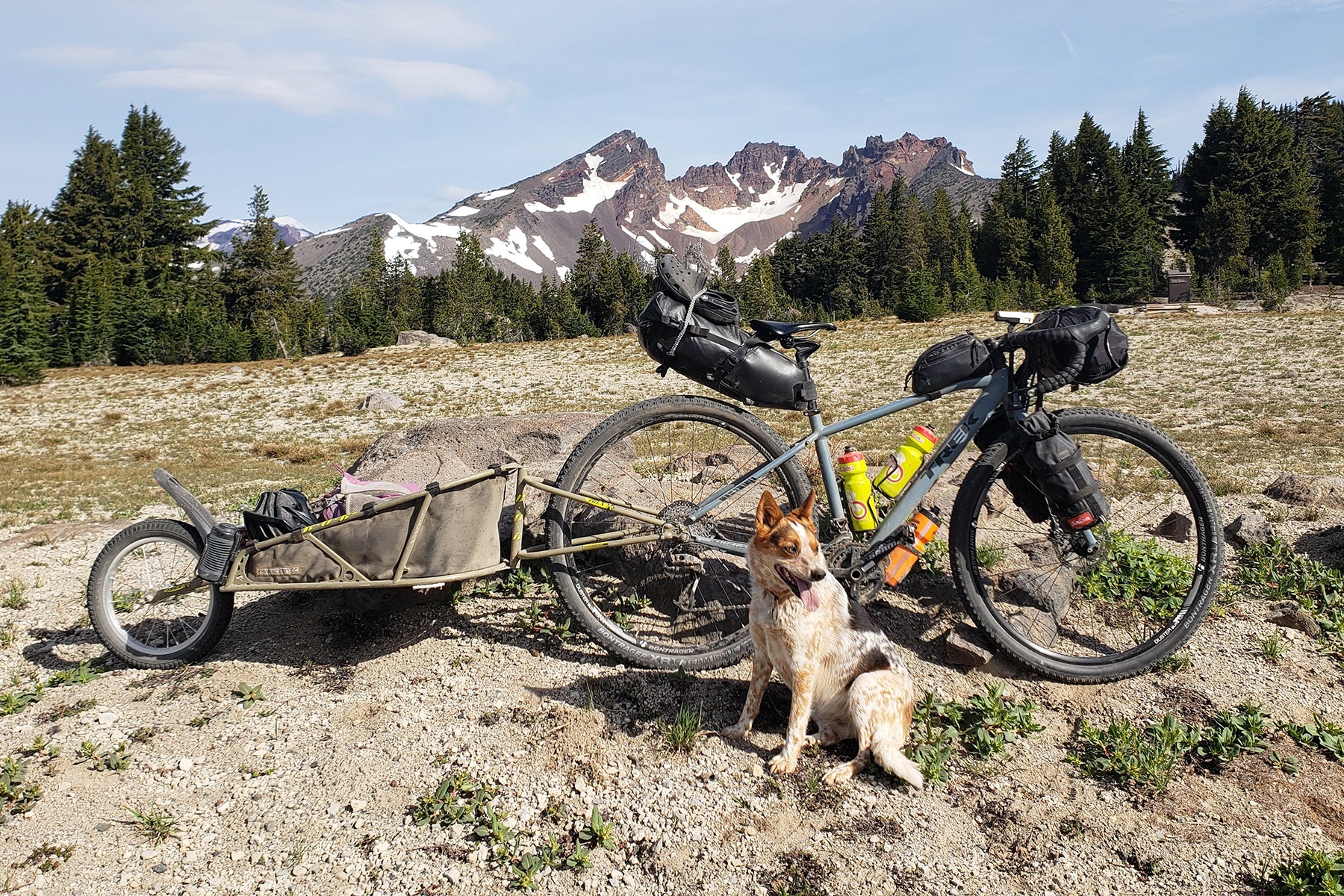 Emma next to the loaded up gravel bike setup with broken Top mountain in the background.