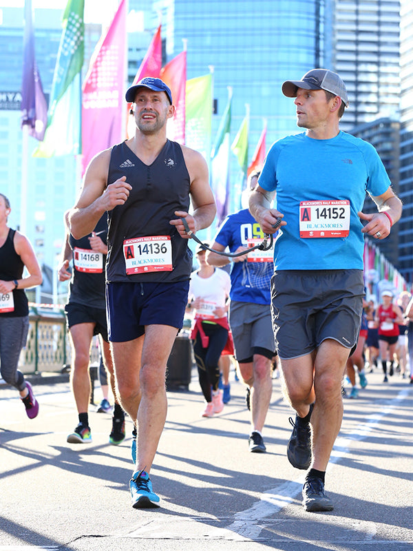 Tom Panek runs a race holding a rope connected to his running guide.