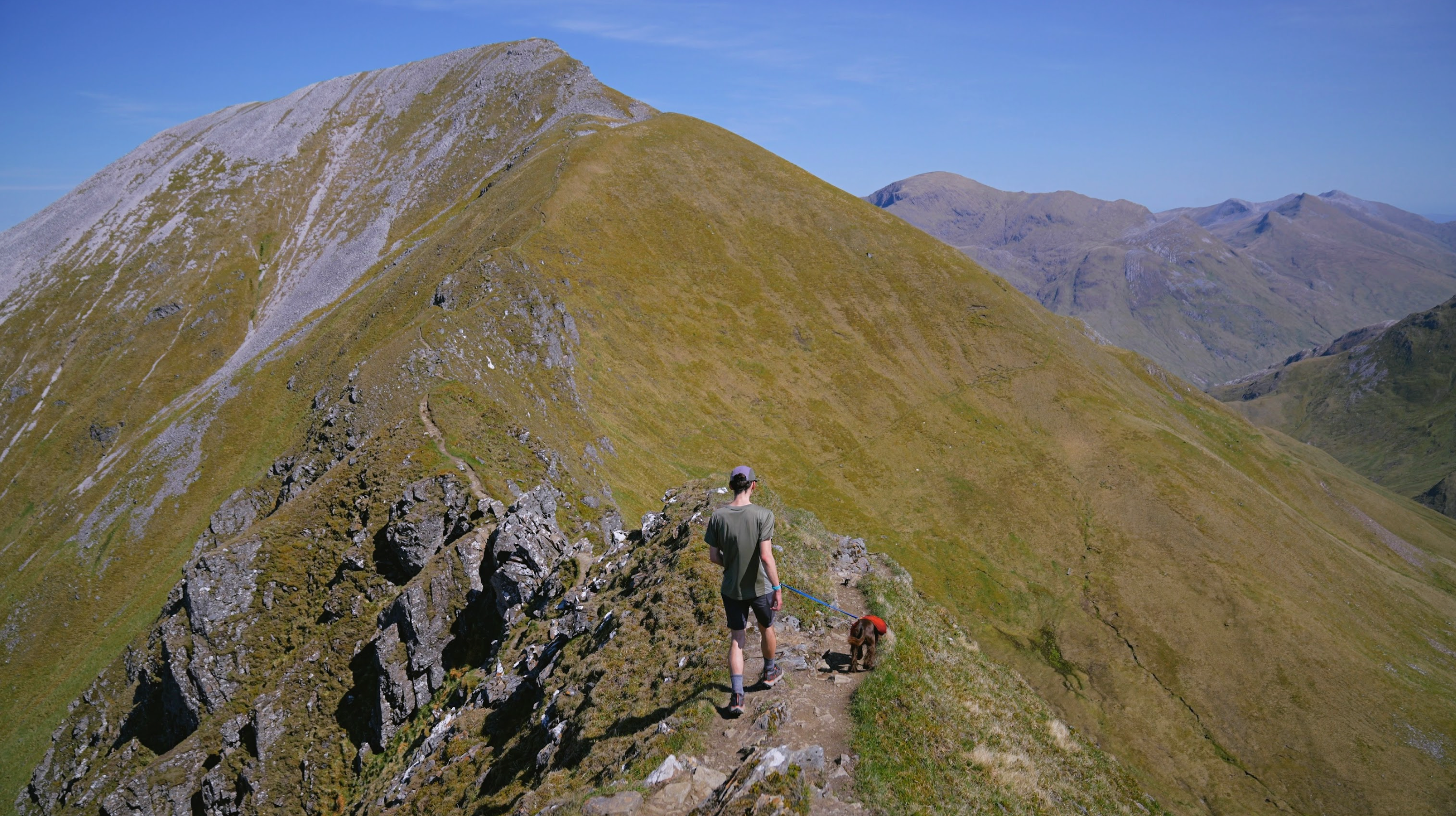 Man and dog hiking on a ridgeline