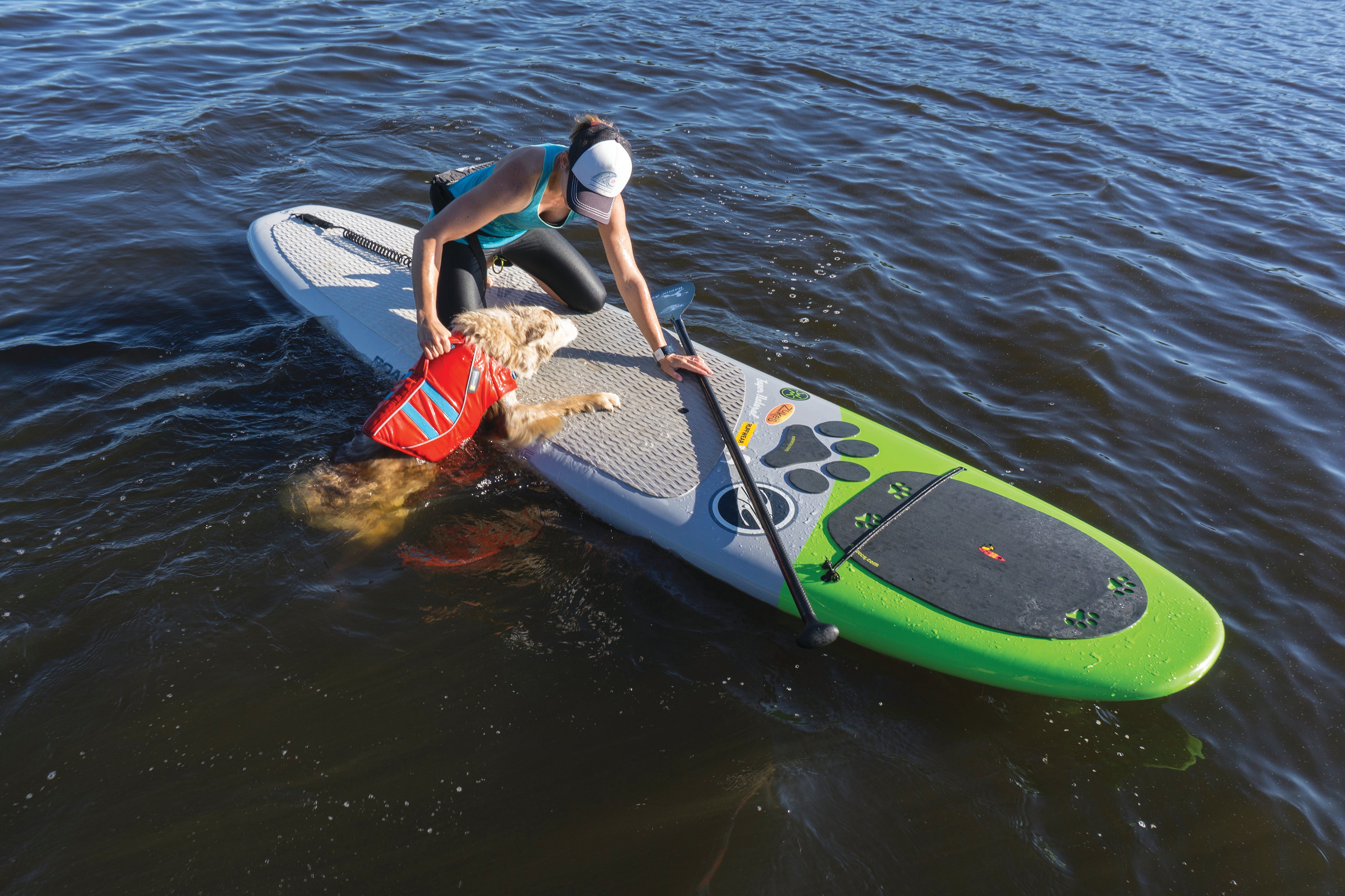 Maria helps bodie onto SUP using float coat handle for lift and assist.