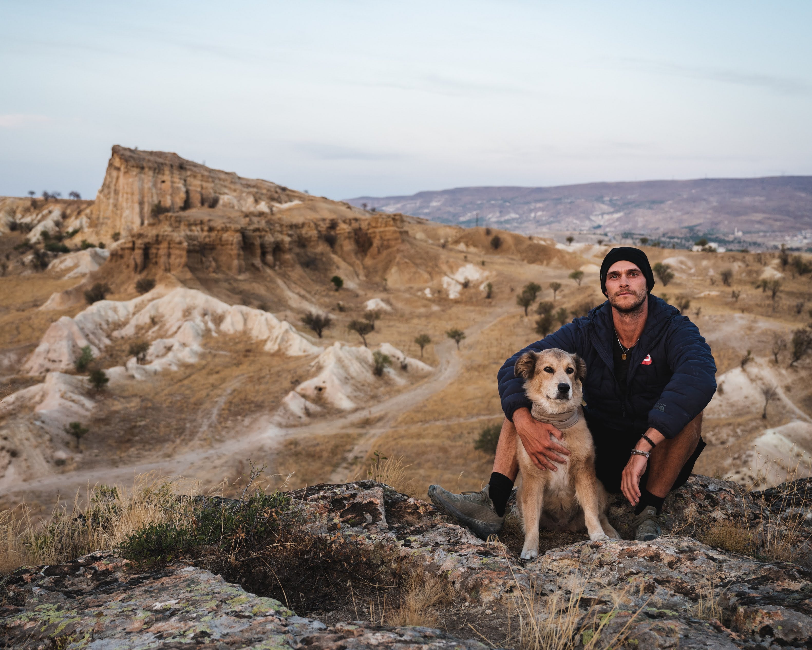 Tom and Savannah sitting in a desert landscape in Turkey