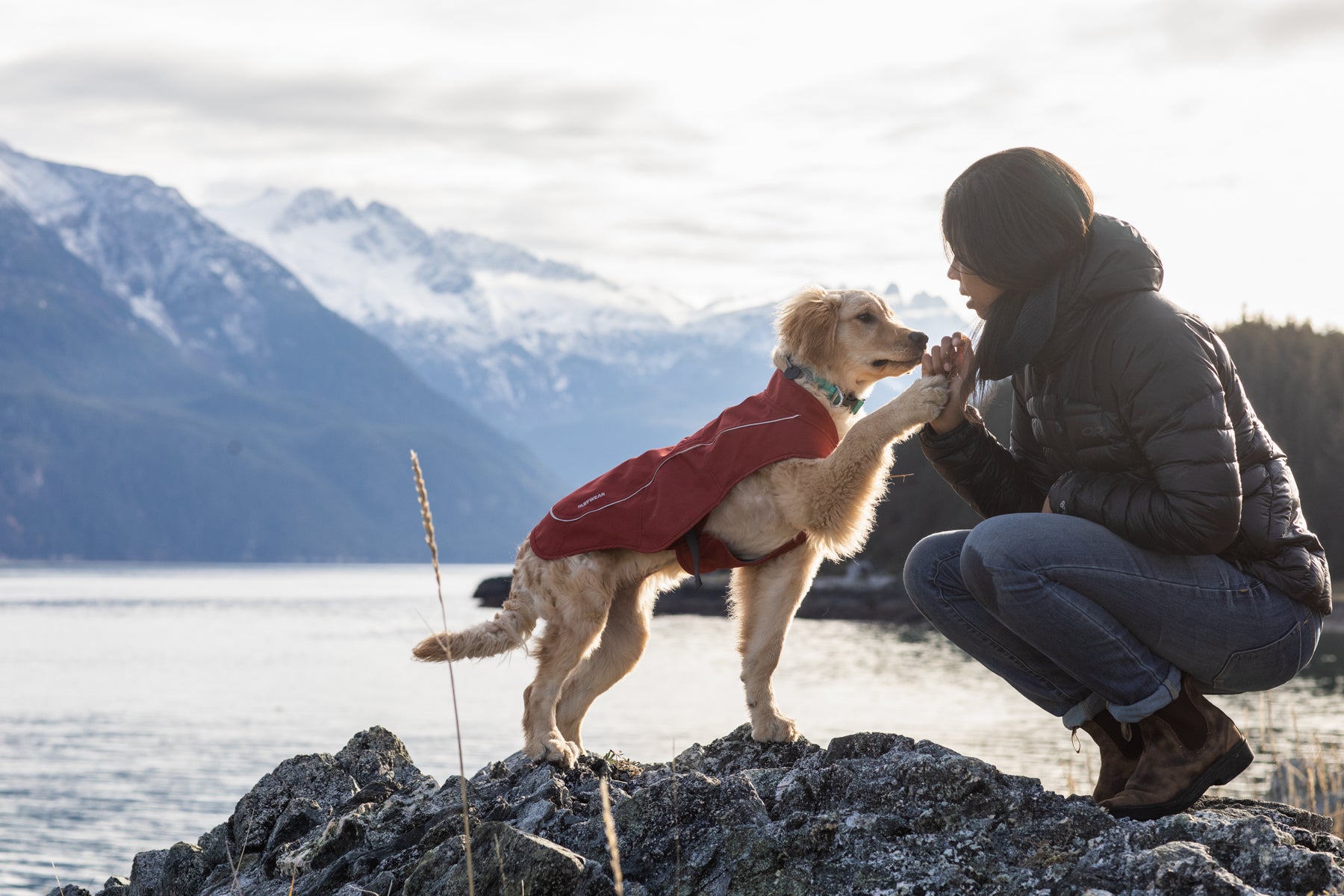 Sammy in Overcoat jacket gives Chris a high five by the river.