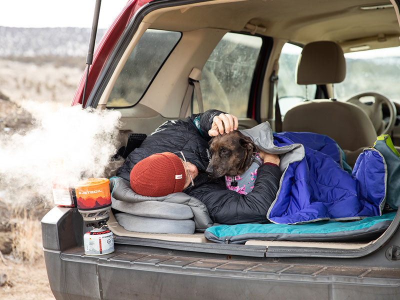 Trevor and Kahlua sleep in the back of the car while water boils on the jetboil.