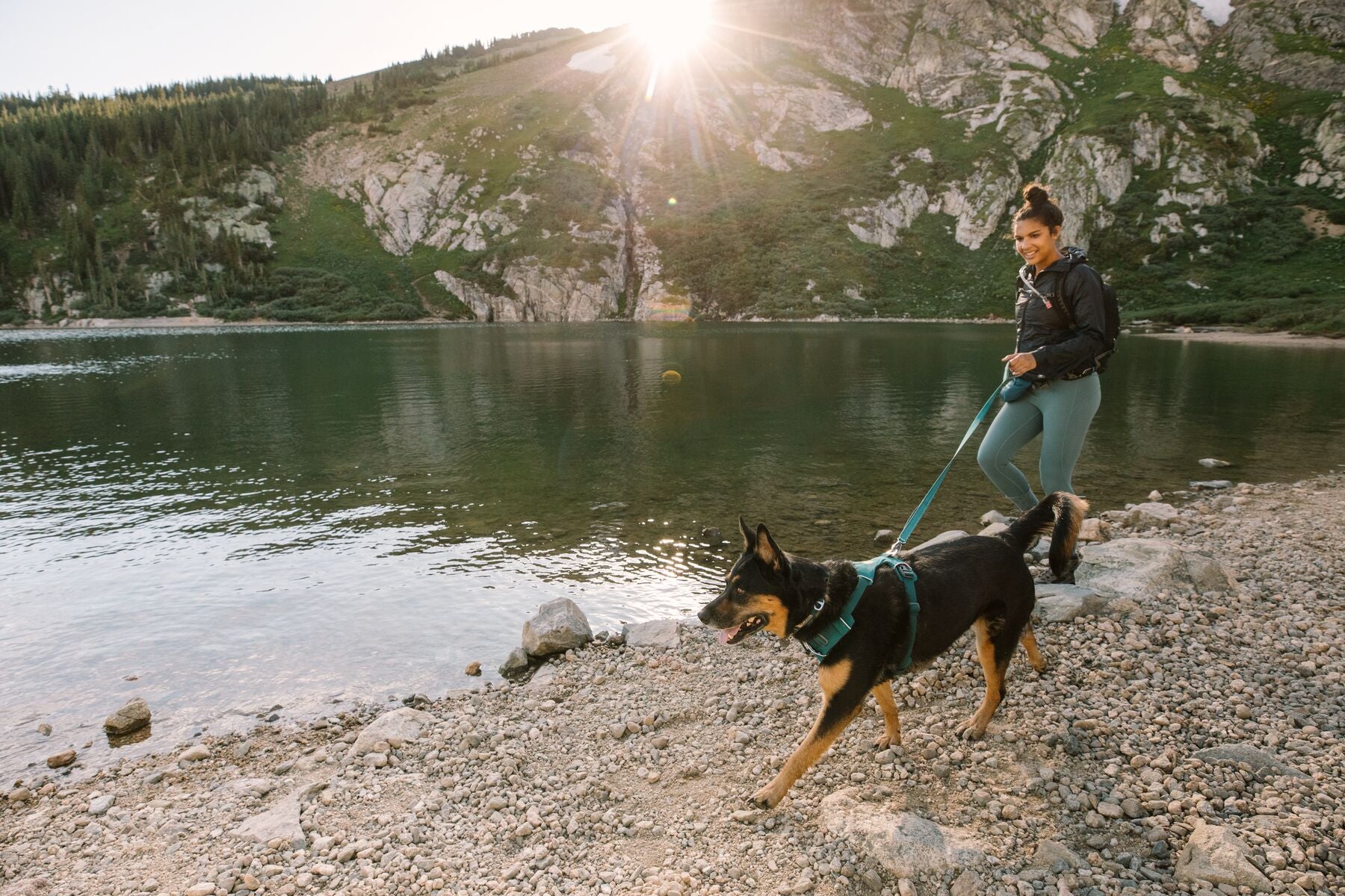 woman and dog walking by a lake