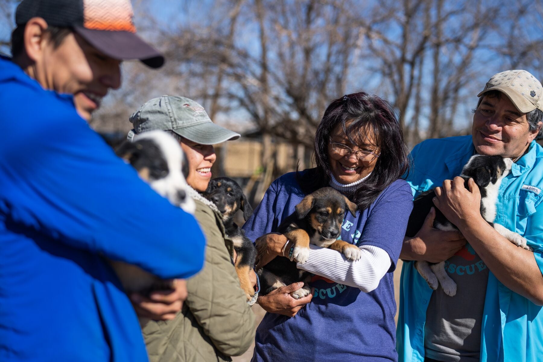 Vernan Kee and members of a dog rescue organization hold puppies who have been rescued.