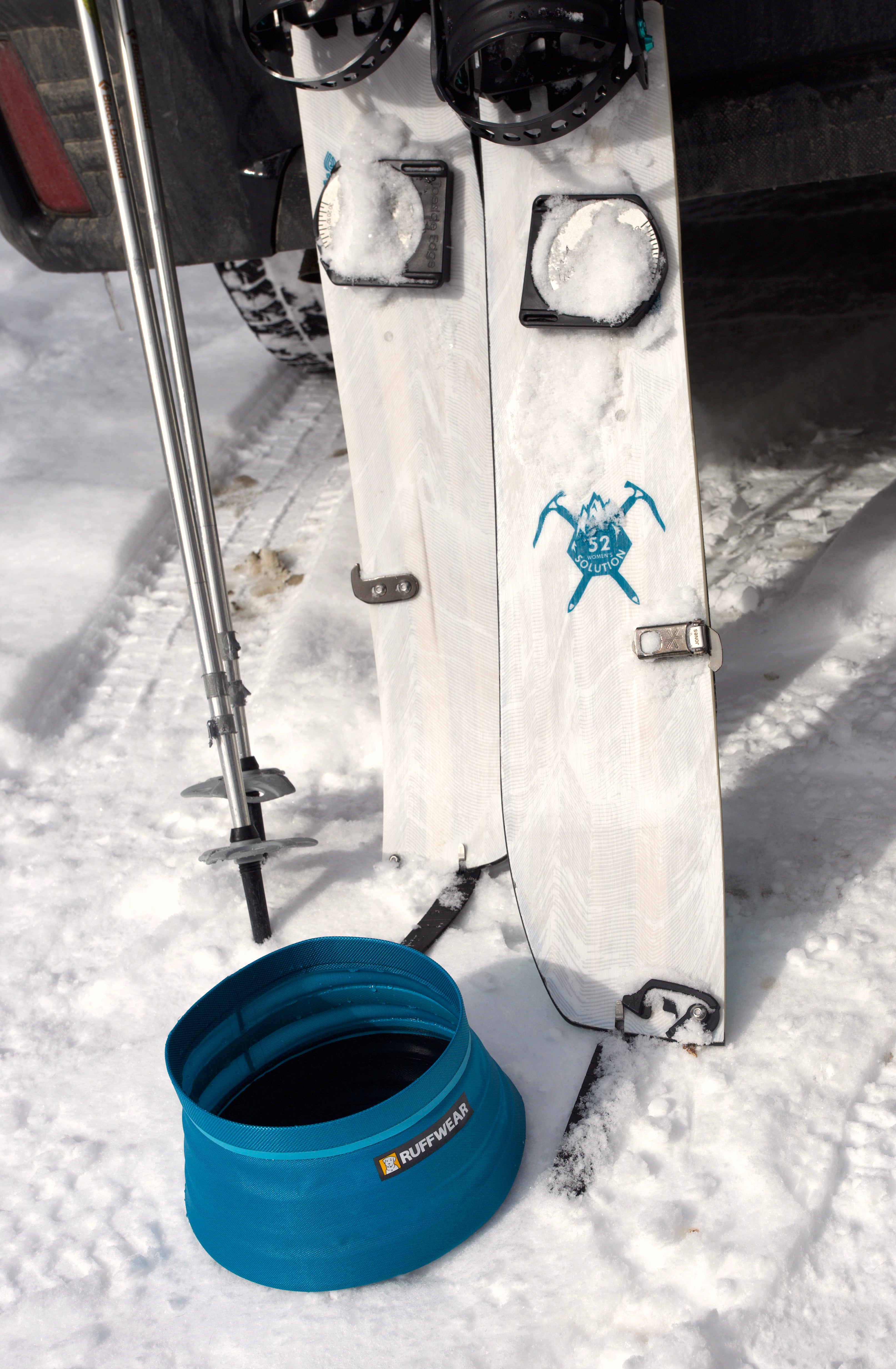 A set of skis next to the Ruffwear Bivy™ Collapsible Dog Bowl. 