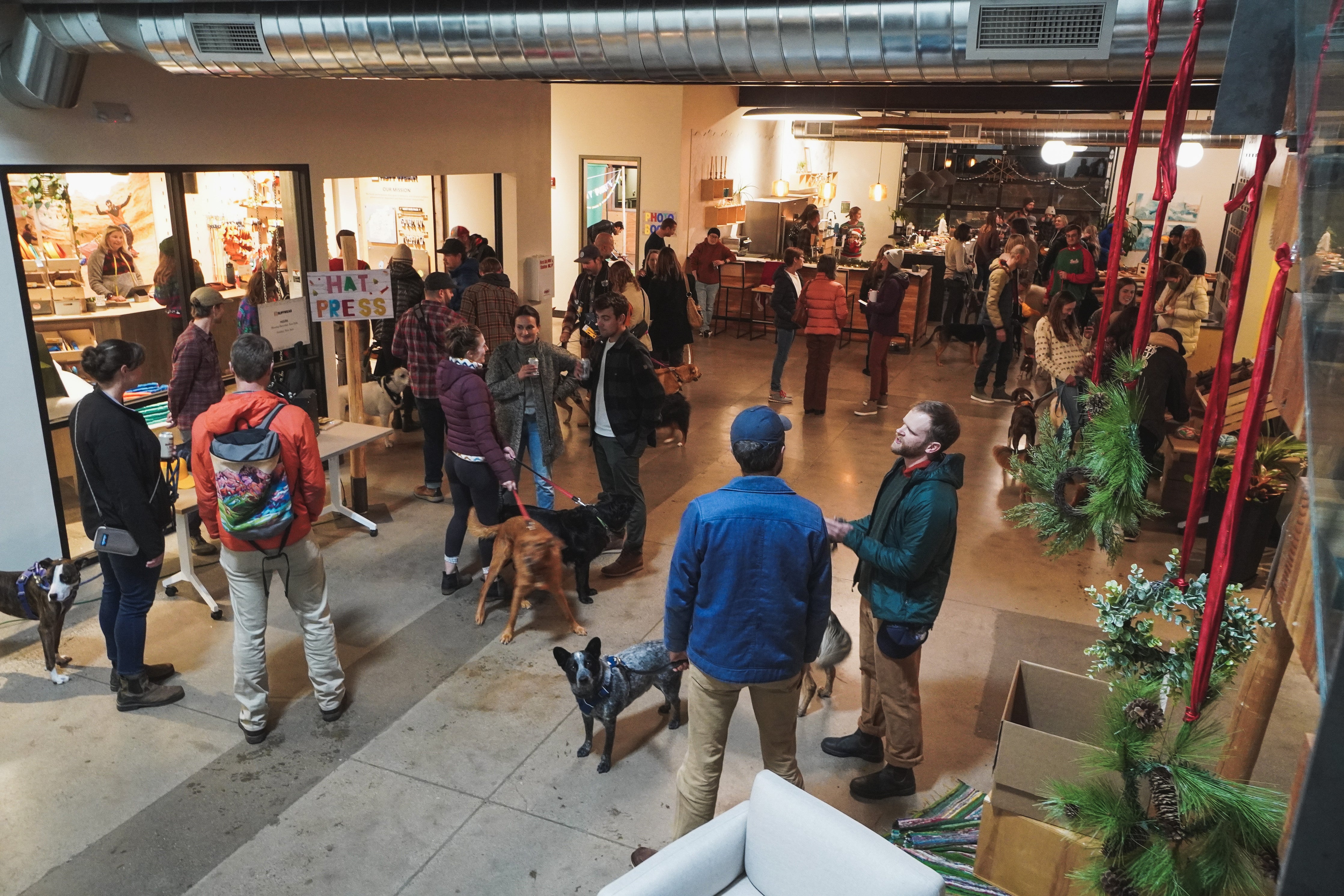 People and their dogs gathering together at the Ruffwear Howliday Party.