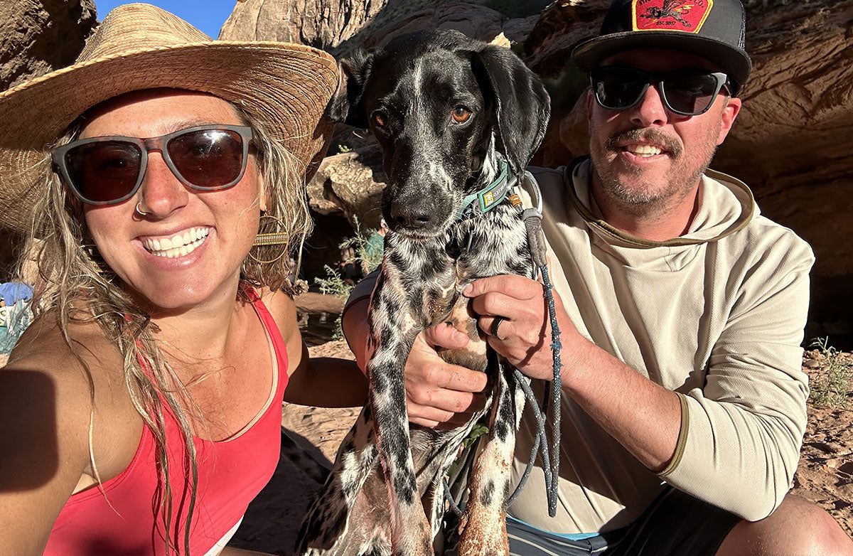 The trio smile at the camera while enjoying some water on a hike.