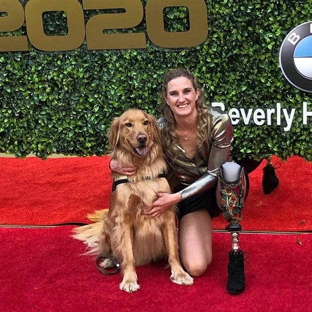 Allysa Seely, a Paralympian, poses with her service dog during an event. 