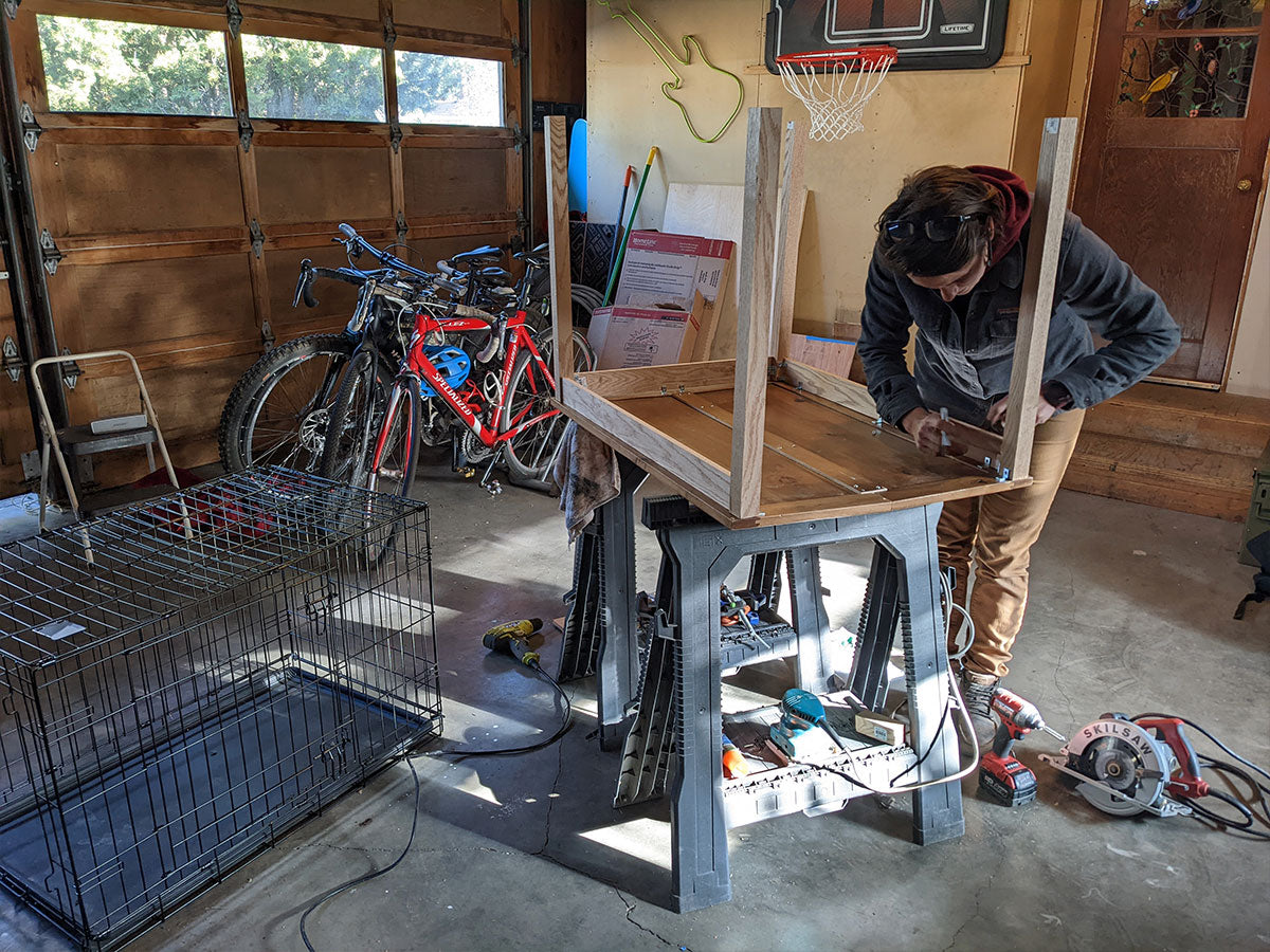 Kadee secures the legs on to the table in her garage.