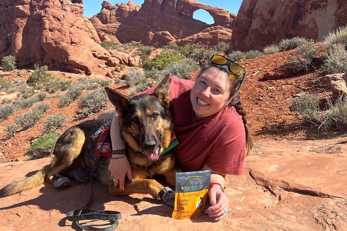 Emma and Zander lay on a rock together in Arches National Park.