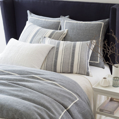 gray blue duvet on bed with white piping
