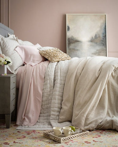 bed with layers room with pale pink walls