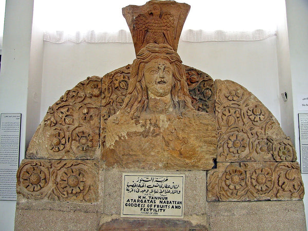 This statue comes from the Nabatean temple at Khirbet Tannur. Atargatis, the "Syrian Goddess" (Lucian, De Syria Dea) was a vegetation goddess, responsible for the fertility of the land, and perhaps the sea as well; her dolphin is a puzzling attribute, which appears on other representations, although not on this one. Here, the goddess emerges from a profusion of vines, fruits, and other vegetation. Her head is crowned by an eagle, symbol of the Edomite god, Qos (Taylor, p. 122).