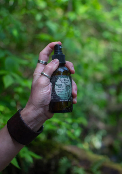 Closeup of someone spraying a Green Fairy scented mist.