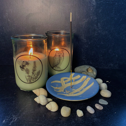 Herbal Renewal and White Lodge candles burning on a black and blue background with incense burning on a blue burner lined with shells and stones